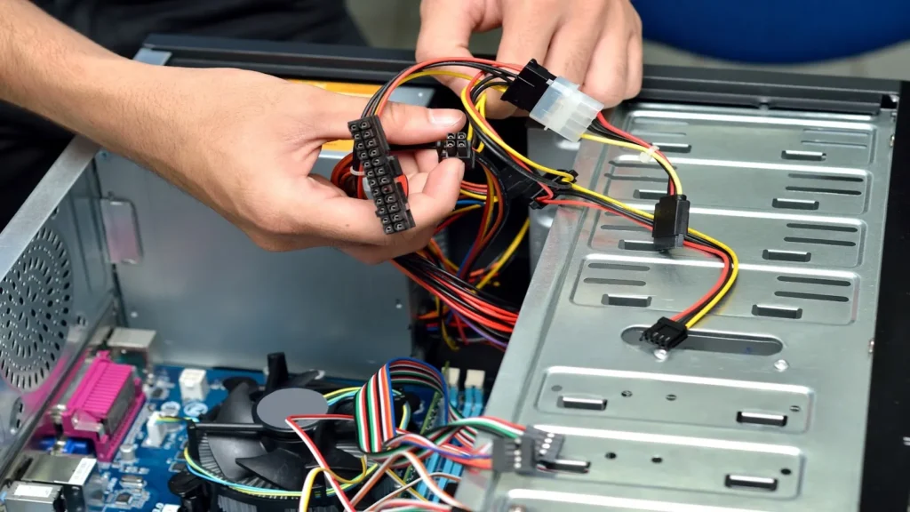 Hands connecting power supply cables inside a computer case, potentially addressing power-related issues like What Does a Red Light on the Motherboard Mean